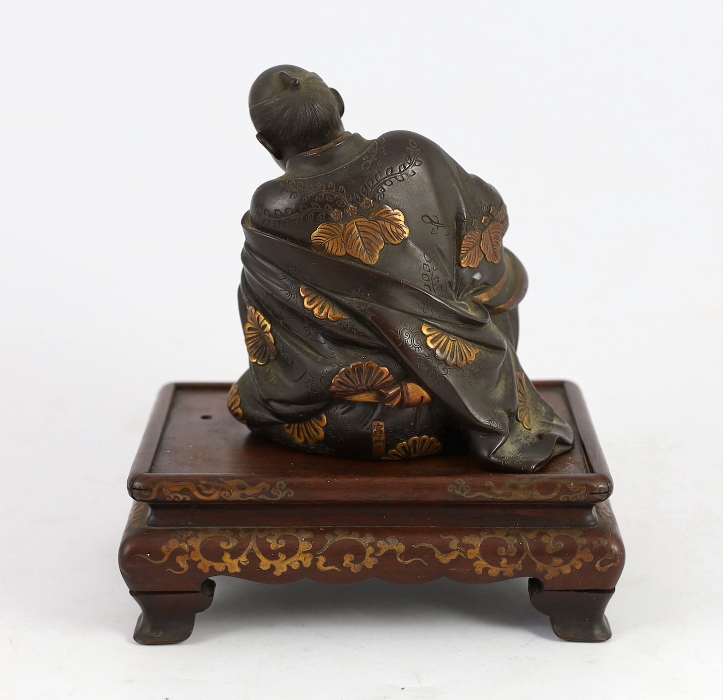 A Japanese bronze model of a sword fittings master craftsman, by Miyao Eisuke, Meiji period, total height 18cm including original gilt lacquered wood stand, small section of bronze lacking